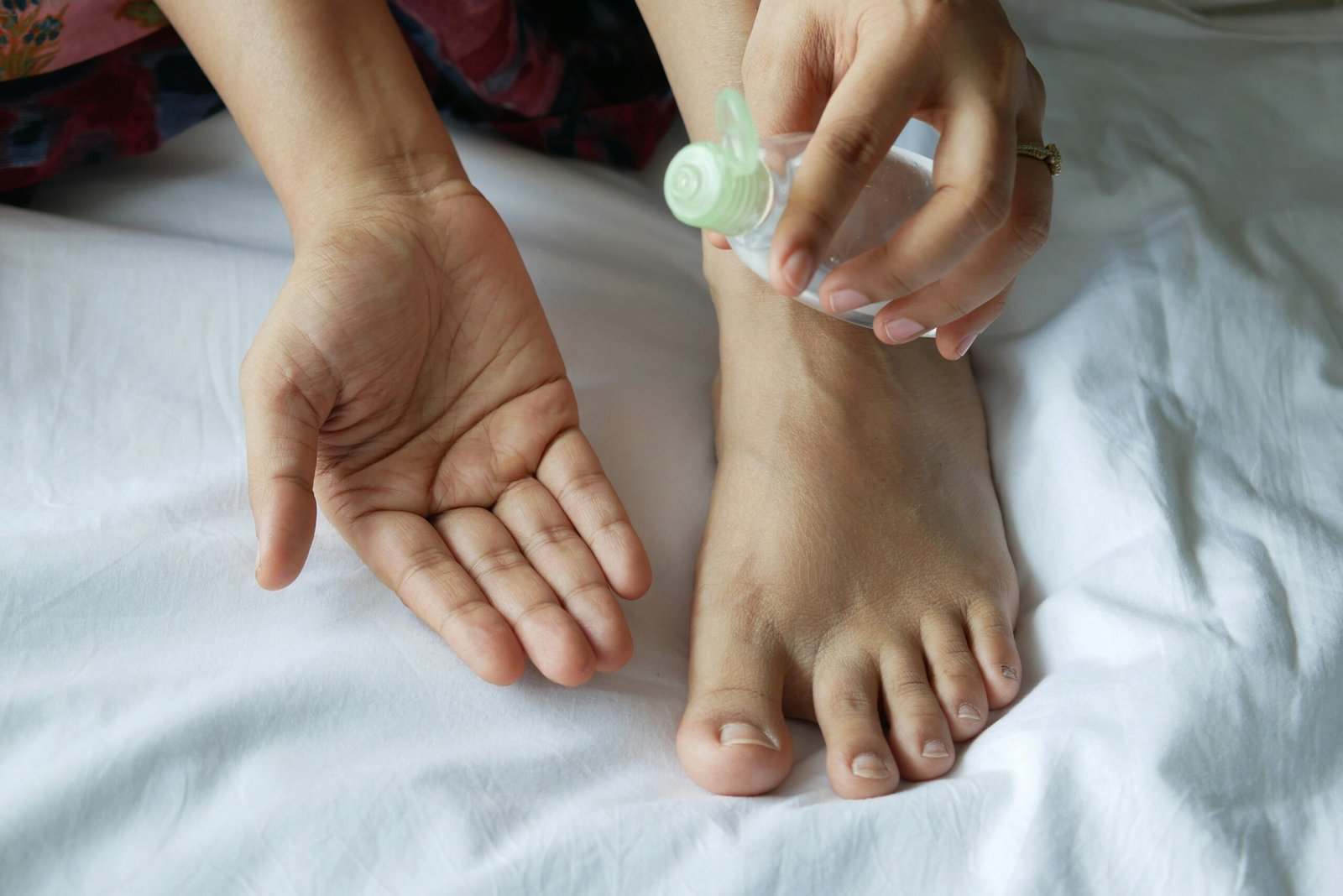 Ayurvedic therapist nurse,a person with a bottle on their foot on a bed